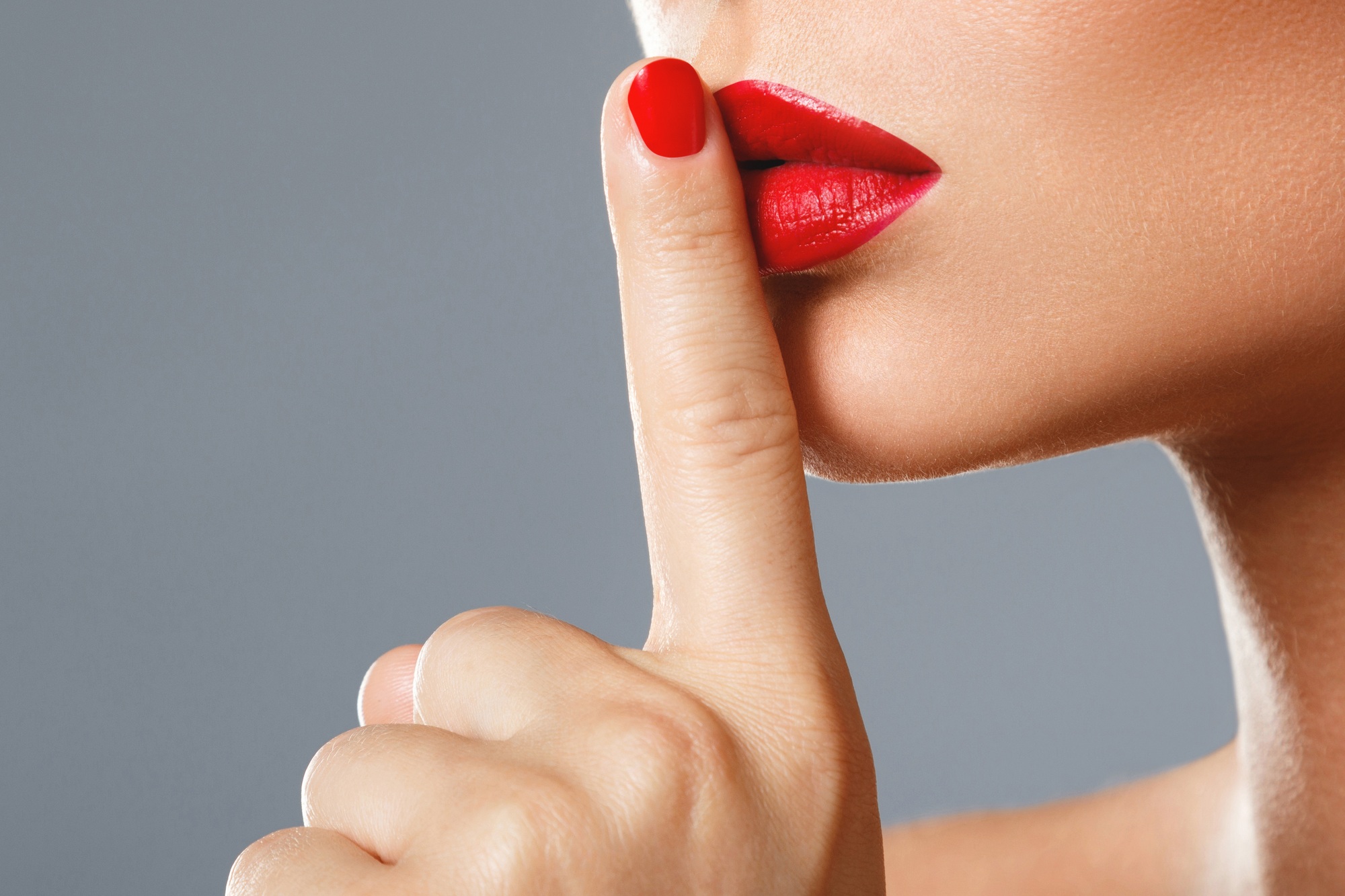 Woman is showing shush or silence gesture