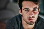 Cropped portrait of a beaten and bruised young man looking down